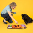 Load image into Gallery viewer, P.L.A.Y. Halloween Snuffle Mat - Dog mom placing treats into mat with little black dog watching
