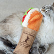 Load image into Gallery viewer, P.L.A.Y. Feline Frenzy Kicker - Tuna Baguette Toy in mouth of a fluffy cat taking a nibble at the sandwich
