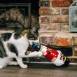 Load image into Gallery viewer, A calico cat playing with a Feline Frenzy Jolly Nutcracker Kicker Toy in front of a brick fireplace.
