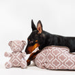 Load image into Gallery viewer, Dog lying on P.L.A.Y. Moroccan Lounge Bed in Ash Gray with matching P.L.A.Y. Upcycled Zoo Pal Bear plush toy next to it on a white background
