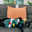 Load image into Gallery viewer, A black cat lies on its back on a gray sofa, cuddling a Feline Frenzy O Christmas Tree kicker toy with white trim and colorful ornaments, while playing with a small gold star toy.
