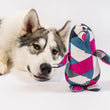 Load image into Gallery viewer, Dog lying next to P.L.A.Y. Upcycled Zoo Pal Penguin plush toy on a white background
