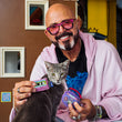 Load image into Gallery viewer, Jackson Galaxy holding a gray tabby cat and the Jackson Galaxy x Feline Frenzy Playback Duo in his hands in front of a cardboard house.

