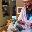 Load image into Gallery viewer, Jackson Galaxy sitting cross-legged on a carpeted floor, interacting with an orange and white cat. He is holding the microphone toy from the Jackson Galaxy x Feline Frenzy Mic Drop Duo while the cat reaches up to grab it.
