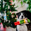 Load image into Gallery viewer, P.L.A.Y. Merry Woofmas Santa's Little Elf-er - black and white dog with elf toy hanging from mouth in front of a Christmas Tree
