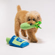Load image into Gallery viewer, P.L.A.Y. Picked Fresh Crunch Bunch Toy: Small dog playing with one of the celery stalks in her mouth and bag on the floor at its feet on a white background
