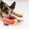 Load image into Gallery viewer, P.L.A.Y.'s Pup Cup Cafe Collection - Doughboy Donut Toy being used by pillow in cattle dog
