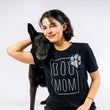 Load image into Gallery viewer, P.L.A.Y. Dog Mom Humanitee - T-Shirt modeled on woman sitting with beautiful black dog putting her head on her shoulder, both smiling and looking at the camera
