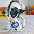 Load image into Gallery viewer, P.L.A.Y. 90s Classics Collection - Game Bone Toy being played with by black and white dog on top of bed
