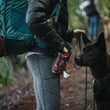 Load image into Gallery viewer, Scout &amp; About Deluxe Training Pouch - Original Mocha Print on human's waist giving treats to black dog on trail
